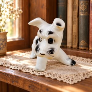 Alba Julia fehér-fekete porcelán foxi kölyök figura fa polcon, könyvek mellett / Alba Julia white and black porcelain fox terrier puppy figurine on a wooden shelf beside books