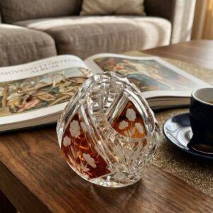 A finely cut crystal basket from Bavaria, featuring a central amber flashed medallion intricately hand-etched with a detailed floral motif. The clear crystal is decorated with deep geometric and starburst cuts. Pristine condition.