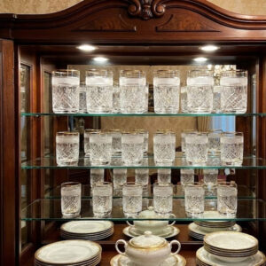 Egy 18 darabból álló kristálypohár készlet a tálaló szekrény polcain