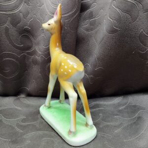 Angled back view of the figurine highlighting its slender legs and graceful posture.
