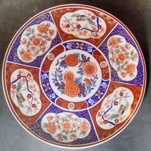 Large Japanese Kozan Gama porcelain charger plate decorated in vibrant Imari style with floral and bird motifs.