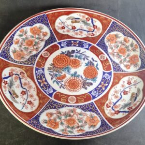 Large Japanese Kozan Gama porcelain charger plate decorated in vibrant Imari style with floral and bird motifs.