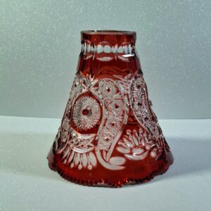 Hand-cut ruby red cased lead crystal lampshade with intricate star and floral patterns, showing deep engravings and heavy glass structure.