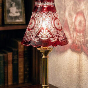 Hand-cut ruby red cased lead crystal lampshade with intricate star and floral patterns, showing deep engravings and heavy glass structure.
