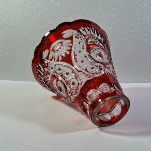 Hand-cut ruby red cased lead crystal lampshade with intricate star and floral patterns, showing deep engravings and heavy glass structure.